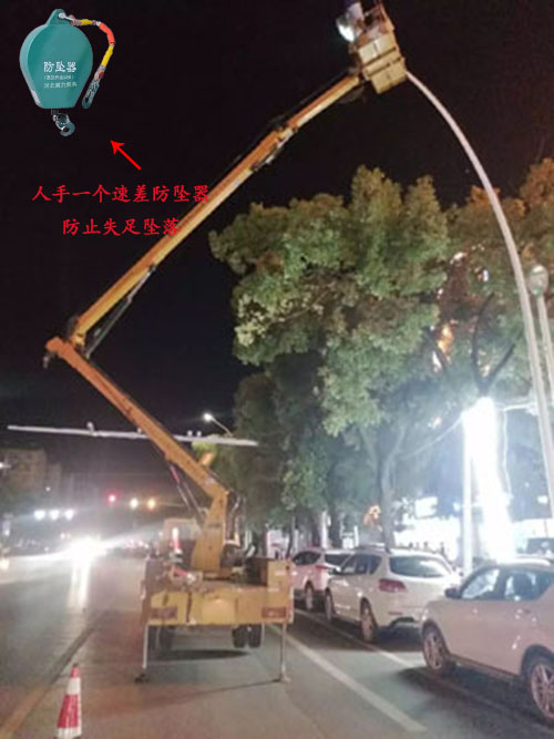 夜晚工人站在升降平臺(tái)車上進(jìn)行路燈更換